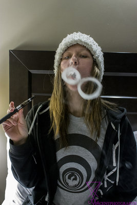 Excellent photo Taylor... whether it was intentional or not, her shirt and the smoke rings match closely. I really like how you composed your shot. Really good work on this one.