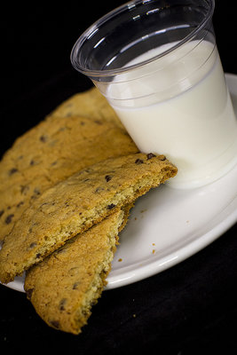 Mmmmm... cookies! These were photographed using a black backdrop so that the plate and the cup of milk would stand out better. It was taken with a 50mm lens at F1.2. The lighting was two LED softboxes. We cut the cookie in half to show the contents. The white balance is set natural in this photo.